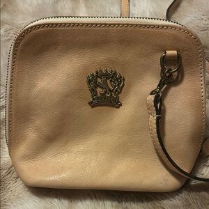 Tan Leather Wristlet with Decorative Emblem